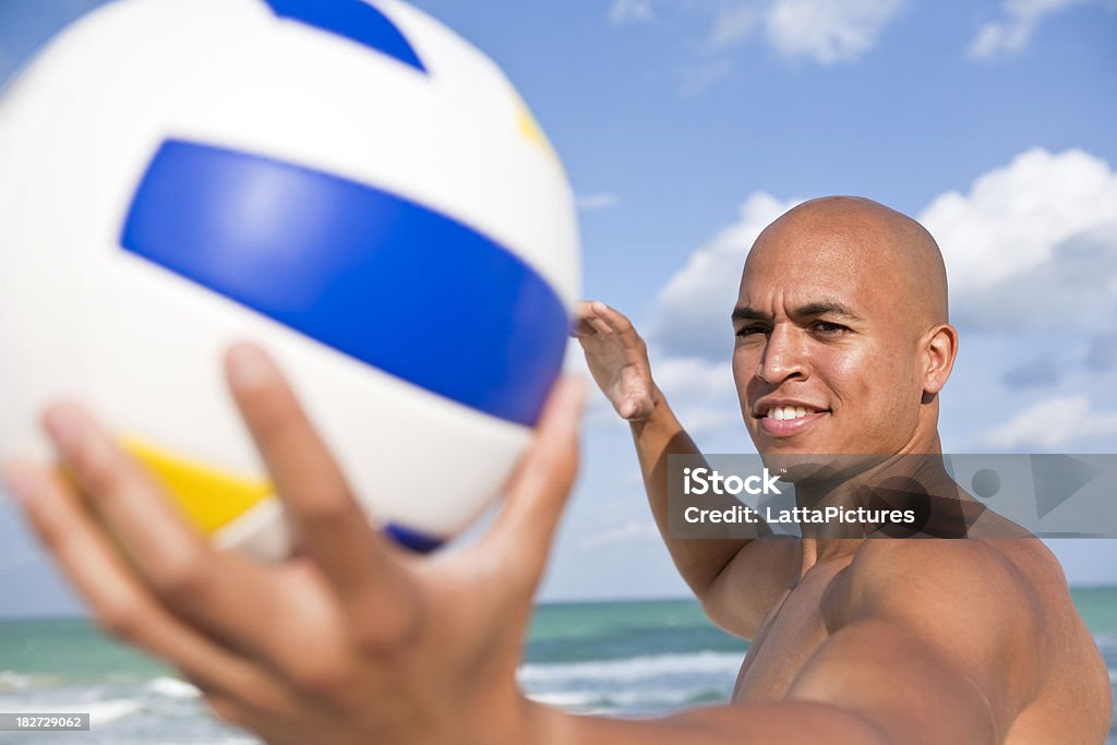 Asiatique africaine mâle tenant prêt à servir de volley-ball sur la plage - Photo de Ballon de volley libre de droits