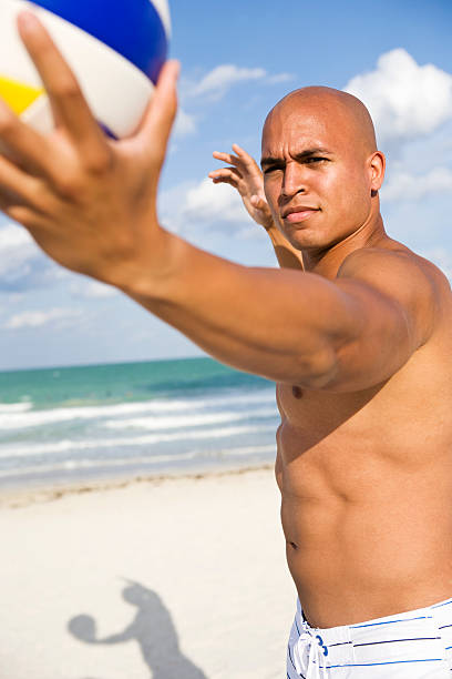 istock Young multi ethnic male serving volleyball on beach 182729067