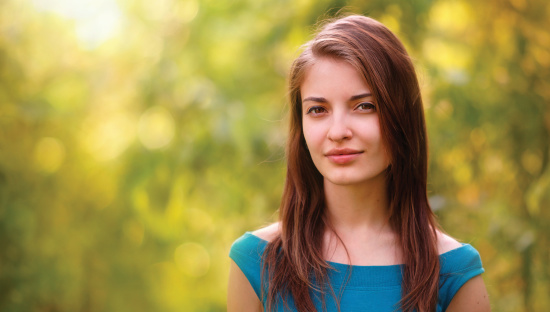 young beauty outdoor portrait in backlight with defocused forest background