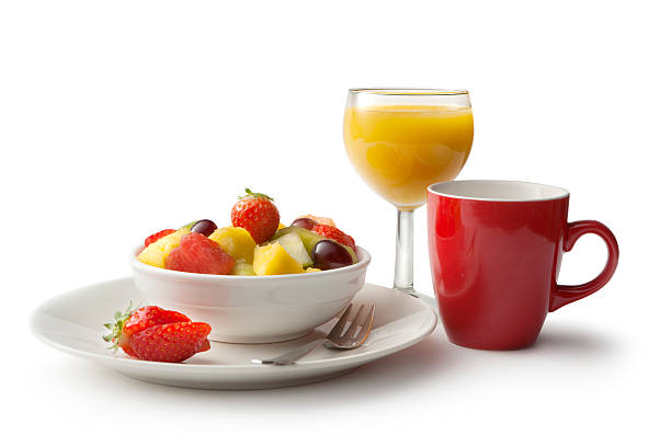 Healthy breakfast with orange juice and a bowl with strawberry, kiwi and pineapple.