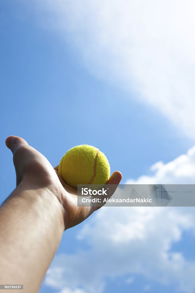 Bola de tenis en las manos contra el cielo azul - Foto de stock de Saque - Deporte libre de derechos