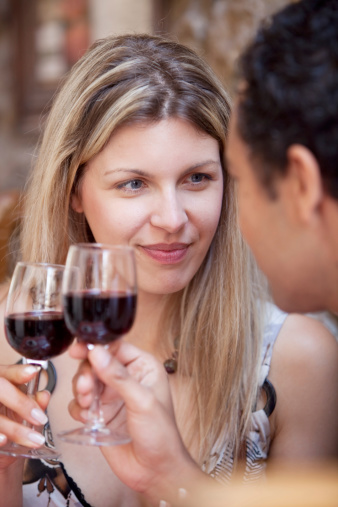 Young couple in restaurant drinking wine.