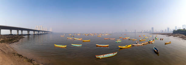 This image captures the Worli Fishing Village in Mumbai, a community steeped in traditional fishing practices, juxtaposed against the backdrop of a rapidly urbanizing city. The village's rustic charm is evident in its small, colorfully painted houses and narrow lanes. However, the photograph also reveals a less picturesque reality of the area – the issue of litter and pollution. The shores and streets are strewn with litter, reflecting a lack of adequate maintenance and waste management in this part of the city. Boats, both docked and preparing to set sail, are seen amidst this setting, symbolizing the daily challenges faced by the community. This image aims to highlight not just the cultural richness and simplicity of life in the Worli Fishing Village, but also the environmental and infrastructural issues that impact it, offering a candid look at the complexities of life in one of Mumbai's oldest fishing communities.