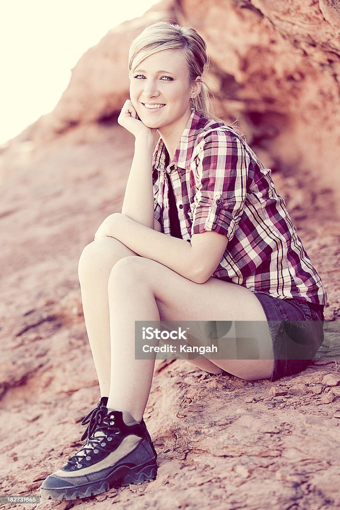 Young Woman Resting Summer portrait of a young woman in her 20s relaxing on the rocks in Utah.Image is processed from a 16 bit RAW file and profiled in ProPhoto RGB. All my images are professionally retouched.More from this Series: 20-24 Years Stock Photo