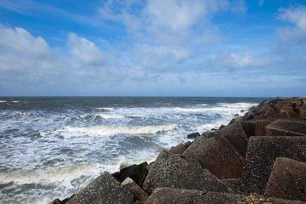 istock waves breaking on the concrete blocks of a jetty 182732731