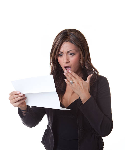 A hispanic woman schocked by the piece of paper she's reading. on a white background.Please see some similar pictures from my portfolio: