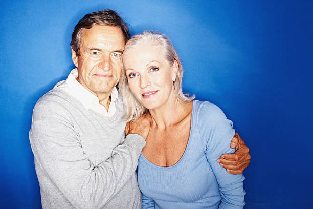 istock Romantic senior couple standing together on blue background 182734516