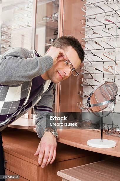 Young Man Trying On Glasses At Opticians Stock Photo - Download Image Now - 25-29 Years, 30-34 Years, Adult