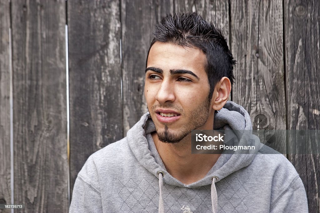 Young ethnic man against black fence 20-29 Years Stock Photo