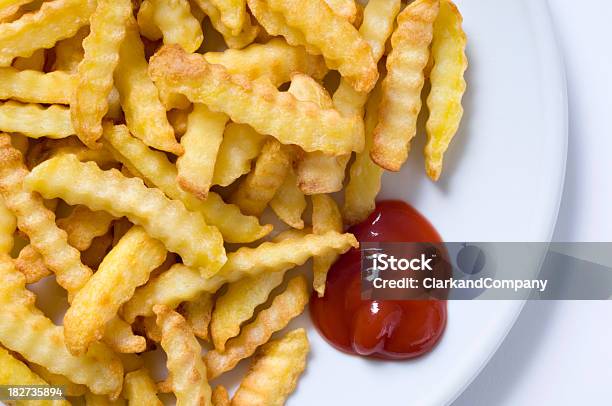 Placa De Corte Crinkle Chips De Batata Frita E Ketchup Fundo Branco - Fotografias de stock e mais imagens de Batata Frita - Lanche