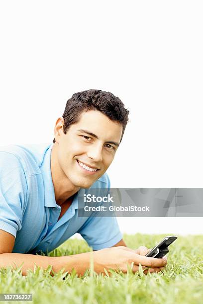 Sorridente Homem Bonito Usando Um Cellphone Na Relva - Fotografias de stock e mais imagens de 20-29 Anos