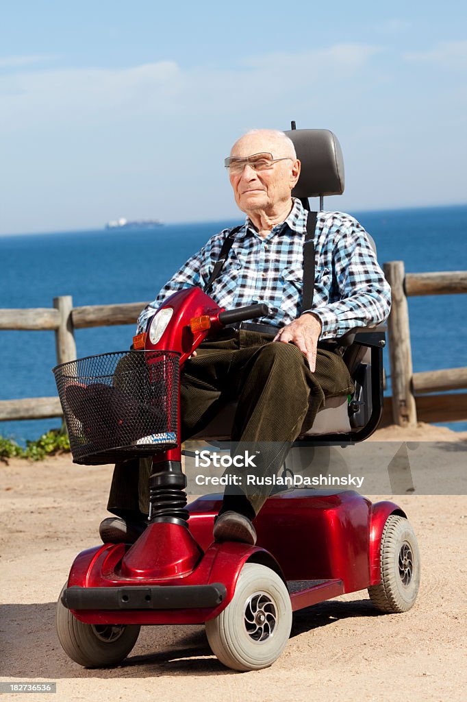 Vecchio uomo che cavalca sul veicolo elettrico - Foto stock royalty-free di Terza età