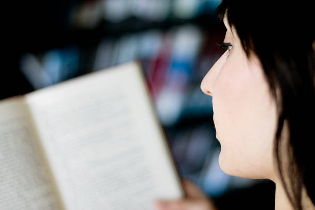 istock Woman Reading a Book at the Library 182736883