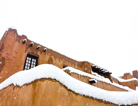 Santa Fe, NM: The old adobe walls of the New Mexico Museum of Art in a snowstorm in downtown Santa Fe. Copy space available in the white sky.