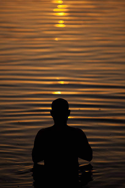 istock Hindu man praying at sunrise in varanasi 182737744