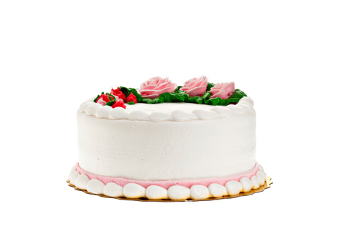 Decorated white cake on a white background. Deliberate copy space provided.