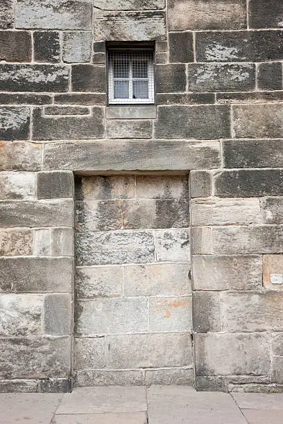 A bricked-up doorway in an old stone wall.