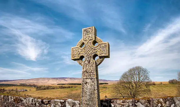 "An old and weathered ancient Celtic cross in a desolate graveyard near Newcastleton, with the rural and remote countryside of the Scottish Borders as a backdrop. Plenty of space for copy and text.More of my images of symbolic British gravestones in this lightbox:"