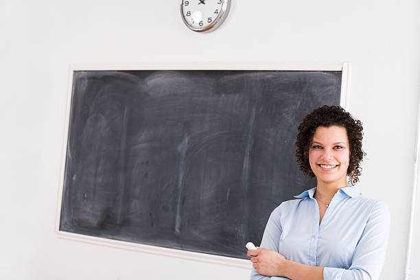 istock Attractive Female Teacher or Student at the Chalkboard 182740925