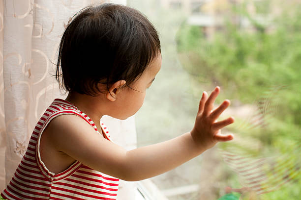 istock Little girl looking out window 182741302