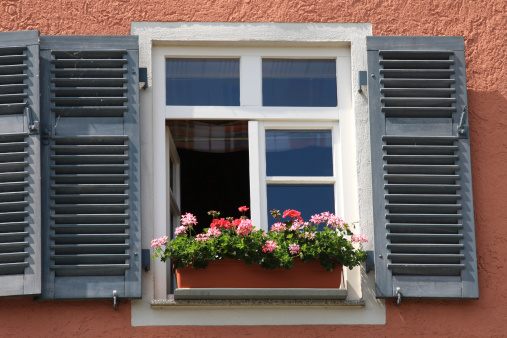 Open window shutters and potted flowers. Spring/summer background.