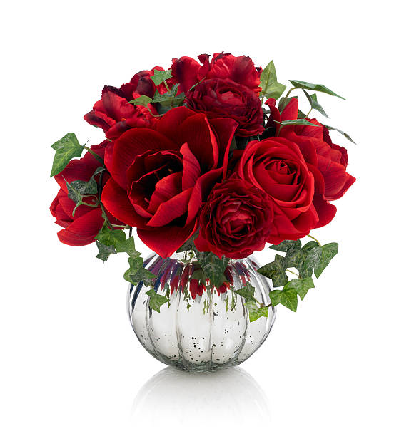 Red roses with some foliage in cut glass vase. Isolated on white.