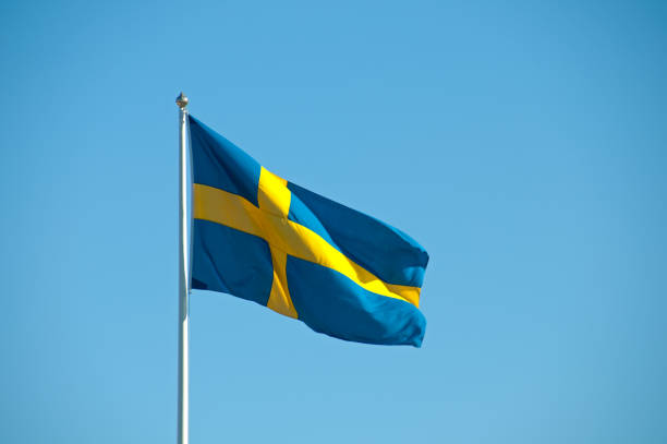 istock Swedish flag against clear blue sky 182742424