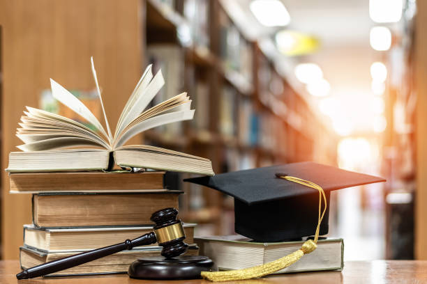 Law education, legal educational study, school for lawyer, legistration, litigation, judicial knowledge learning concept with court judge gavel and textbook with mortarboard on books in library stock photo