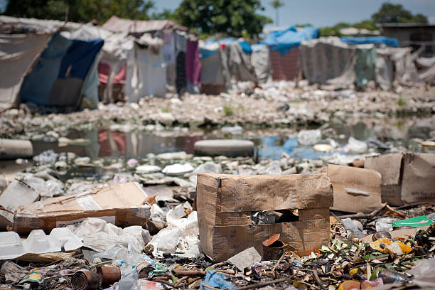 Water pollution in refugee camps "Boxes and plastic bottles in foreground, refugee tents in background.See other photos of Haiti:" vibrio stock pictures, royalty-free photos & images