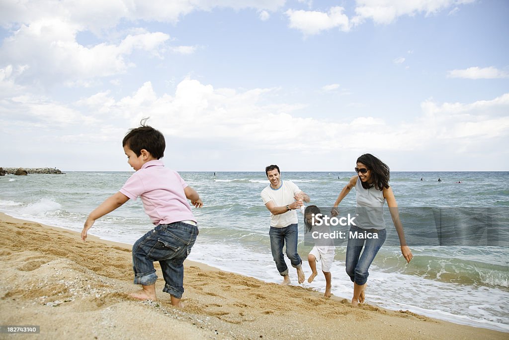 Famiglia in spiaggia godendo le vacanze - Foto stock royalty-free di 30-34 anni