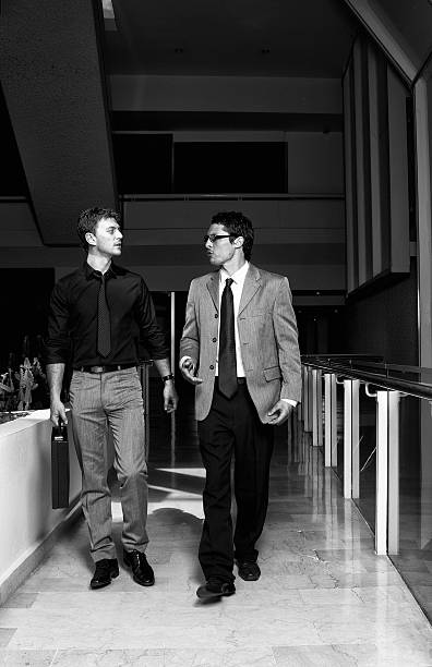 istock Two young businessman walking and talking 182743260