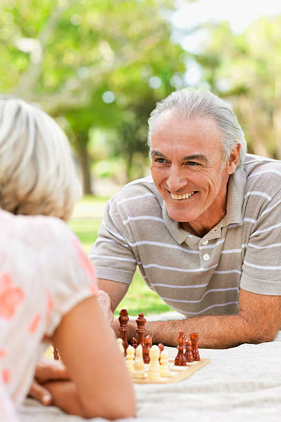 istock Senior Couple Playing Chess in the Park 182743390