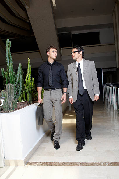 istock Two young businessman walking and talking 182744196