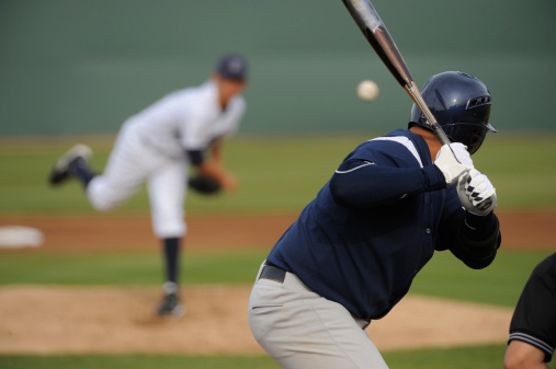 A baseball player looks at a pitch during a game.