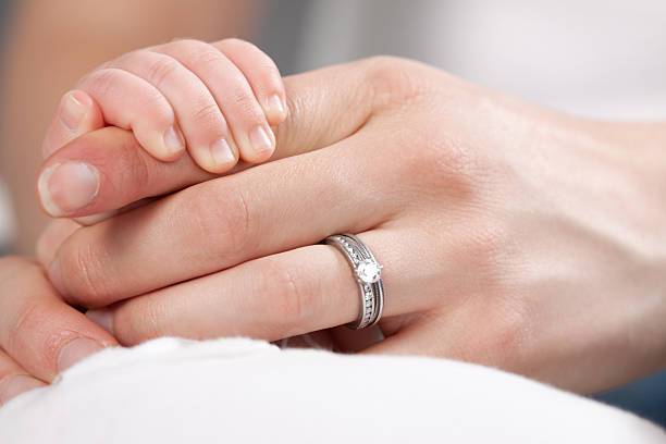 持つ母の手を赤ちゃん - solitaire ring ストックフォトと画像