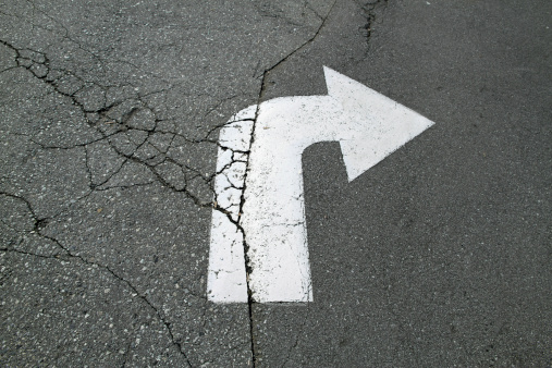 A cracked and weathered right turn arrow.
