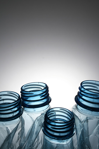 Closeup view of tops of four plastic bottles. Shallow depth of field