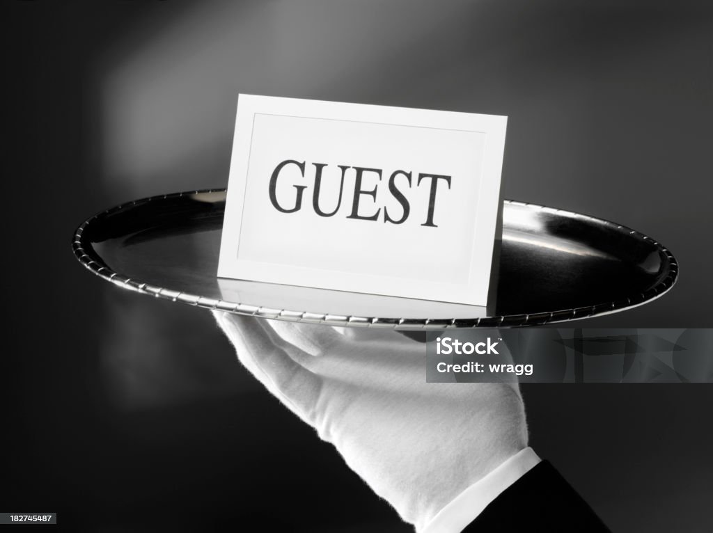 Serving Guests with a First Class Service First class service. Waiter holding a guest card on a silver tray.  Adult Stock Photo