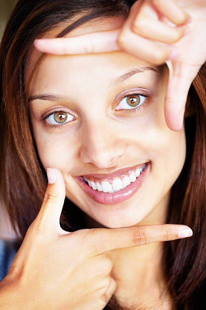 istock Smiling pretty female with hand frame in front of face 182745566