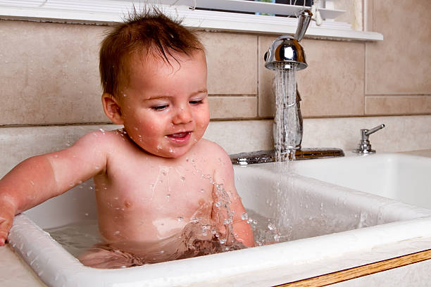 istock Cute Baby Boy Bathing in Kitchen Sink 182746423