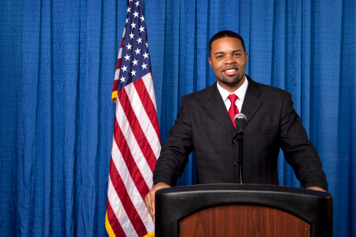 Image of a microphone interviewing an executive wearing a suit