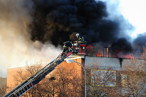 los bomberos en escalera la lucha contra incendios - heat loss fotografías e imágenes de stock