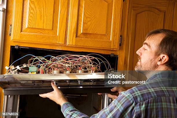 Repairing An Oven Stock Photo - Download Image Now - 40-44 Years, 45-49 Years, Adult