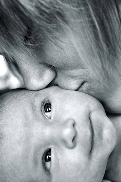 istock Mother Kissing Smiling Newborn 182748464