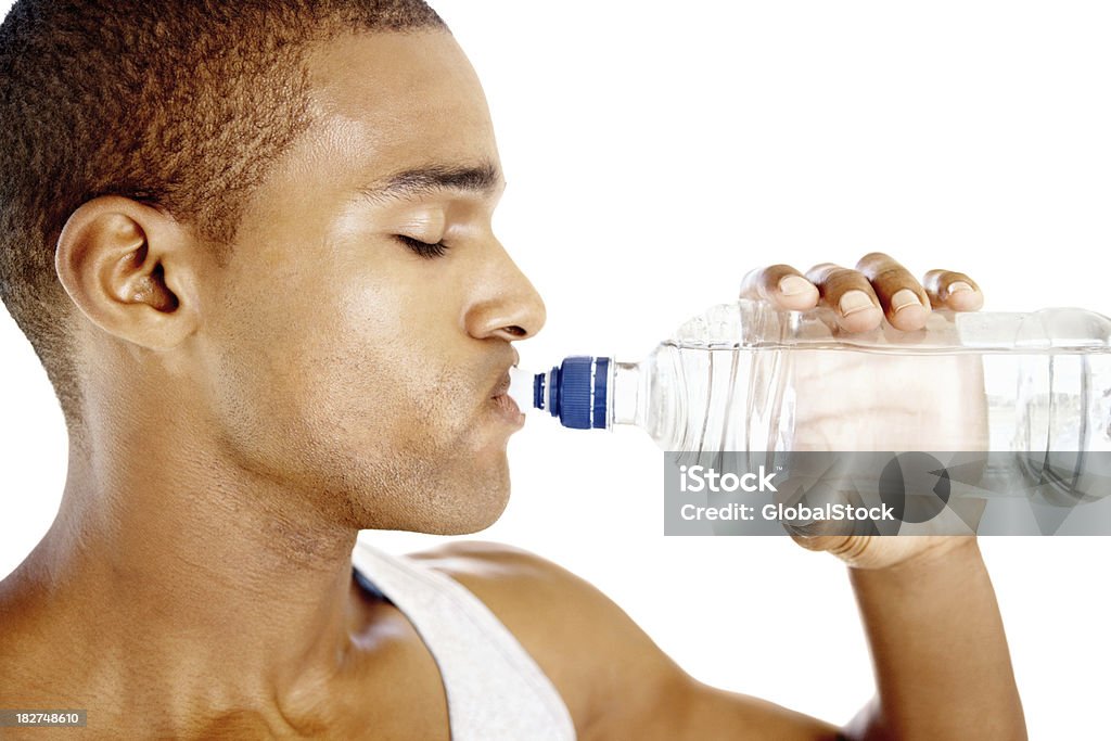 Молодой человек питьевой воды в бутылках изолированные против белый - Стоковые фото 20-29 лет роялти-фри