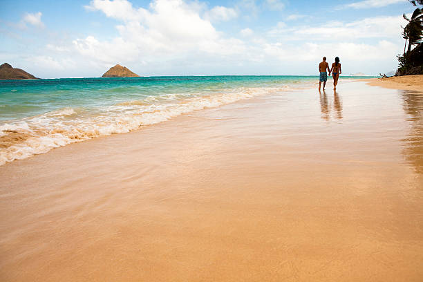 istock A couple holding hands and waking down a beach 182748946