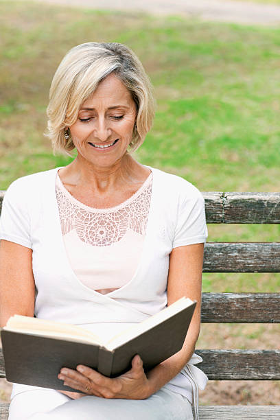 istock Senior Woman Reading on a Park Bench 182749141