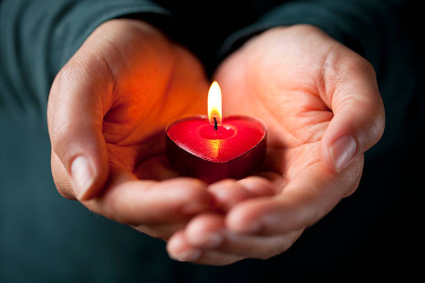 en forma de corazón con velas en las manos - love hope valentines day horizontal fotografías e imágenes de stock