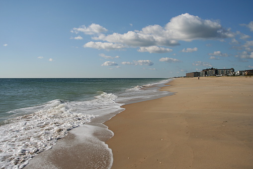 Sea, sand, sun and cloud.  Condos in the distance at Bethany Beach, Delaware.