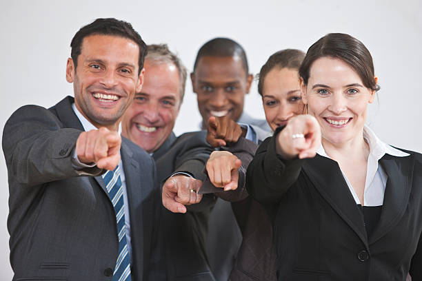 istock happy mature Business Group pointing 182750018